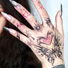 a woman's hand with tattoos on it and her fingers in the shape of hearts