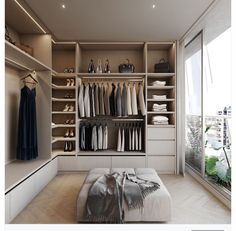 an image of a walk in closet with clothes on the shelves and shoes on the floor