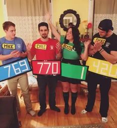 four people holding up signs in the middle of a room