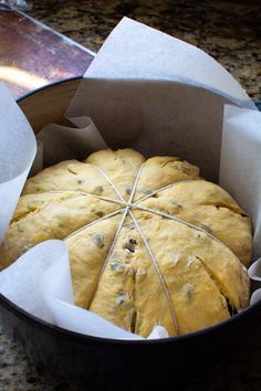 a pan filled with bread sitting on top of a counter next to some paper wrapped around it