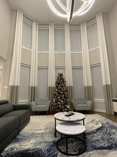 a living room filled with furniture and a christmas tree in the middle of the room