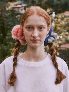 a woman with red hair and two braids in her hair, wearing a white t - shirt