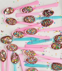 spoons filled with chocolate and sprinkles on top of a table