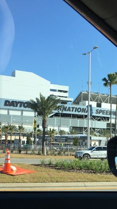 an airport with cars parked in front of it and traffic cones on the side of the road