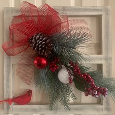 a red bird sitting on top of a window sill next to a christmas decoration