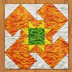 an orange, yellow and green quilted design on a wooden surface