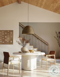 a dining room table with chairs and a vase on the table in front of it