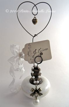 a small white bell with a tag attached to it's side and bells around the bell