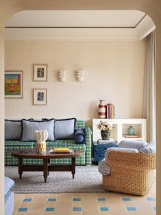 a living room filled with furniture and decor on top of tile flooring next to a window