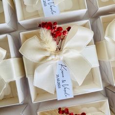 several boxes with white bows and red berries on them