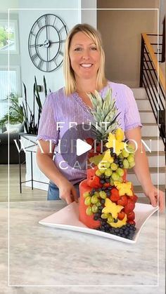 a woman standing in front of a tray filled with fruit