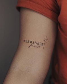 a person with a small tattoo on their arm that says permanence grace in black ink