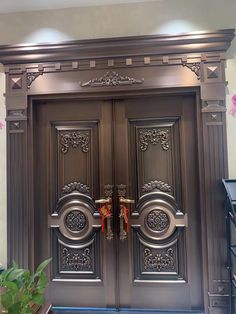 an ornately decorated double door is shown in front of a wall with pink flowers