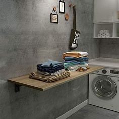 a washer and dryer in a small room next to a counter with towels on it