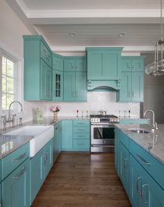 a kitchen with teal cabinets and white counter tops is pictured in this image from the front view