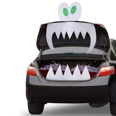 an open car trunk with monster teeth on it's hood and eyes painted white