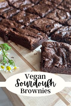 vegan brownies on a cutting board with flowers in the foreground and text overlay that reads vegan sourdough brownies