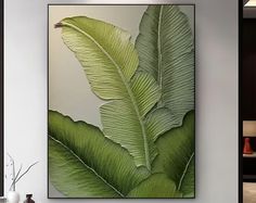 a large green leaf is hanging on the wall