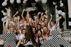 a group of young women standing next to each other with their hands in the air