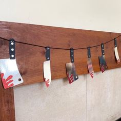 five knives hanging on a wall with hand prints