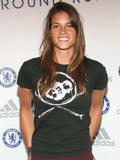 a woman standing in front of a wall with a skull and crossbones on it