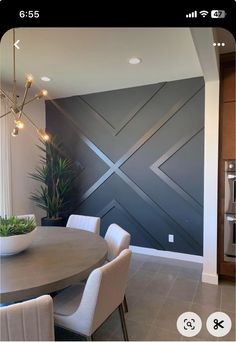 a dining room table with white chairs next to a wall that has an x design on it