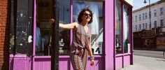 a woman standing in front of a purple store