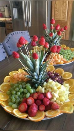 two plates filled with fruit on top of a wooden table