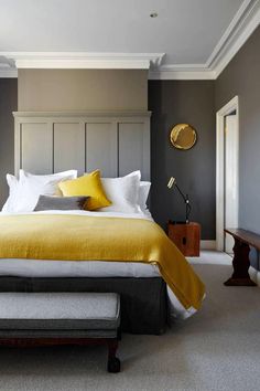 a bedroom with gray walls and yellow accents