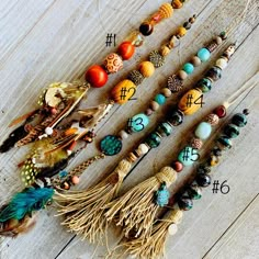 a number of beads and feathers on a wooden surface with numbers in the middle one is for each bead