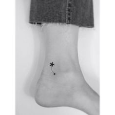 a black and white photo of a person's foot with a star tattoo on it