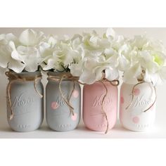 three mason jars with flowers in them are painted pink, blue and gray to match each other