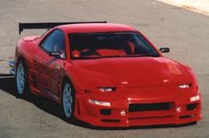 a red sports car is parked on the street