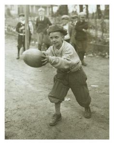 an old black and white photo of a boy holding a ball