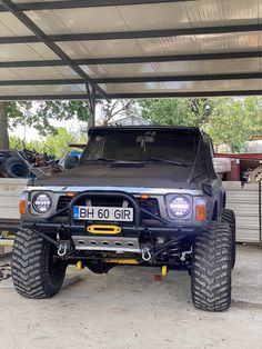 a black four wheel drive vehicle parked under a covered area