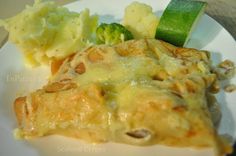 a white plate topped with cheesy potatoes and broccoli