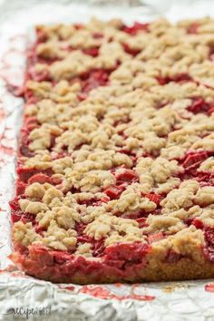 a pie with crumbs on it sitting on top of tinfoil covered baking sheet