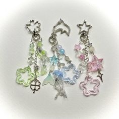 six charms with different designs on them are shown in various colors and sizes, including pink, green, blue, white