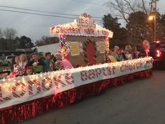 a parade float is decorated with candy canes and christmas lights as it passes down the street