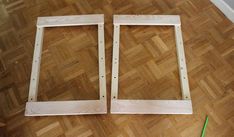 two wooden frames sitting on top of a hard wood floor next to a green pencil