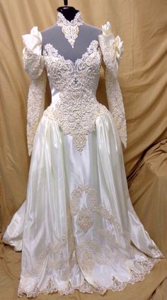 a white wedding dress with long sleeves and flowers