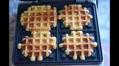 four waffles sitting on top of a black pan