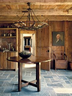 a dining room table with a bowl on it in front of wooden walls and shelves