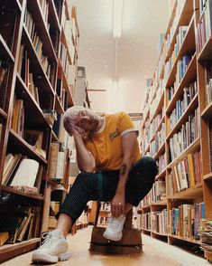 a man sitting on top of a stool in a library