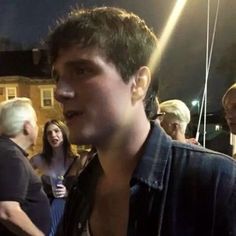 a man standing in front of a group of people at an outdoor event and talking to each other