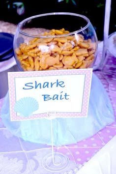 a bowl filled with food sitting on top of a table next to a sign that says shark bait