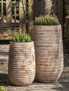 two large vases sitting on top of a stone walkway