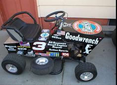 a go - kart with wheels and tires is parked on the side of a building