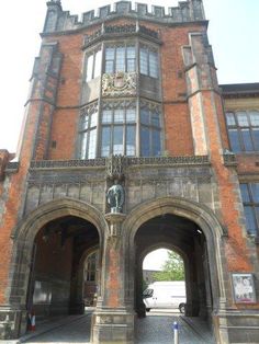 an old brick building with arched doorways and statues on the front entrance to it