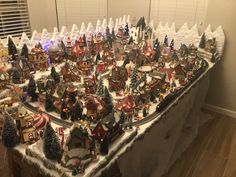 a table covered in lots of different types of christmas decorations and trees on top of it